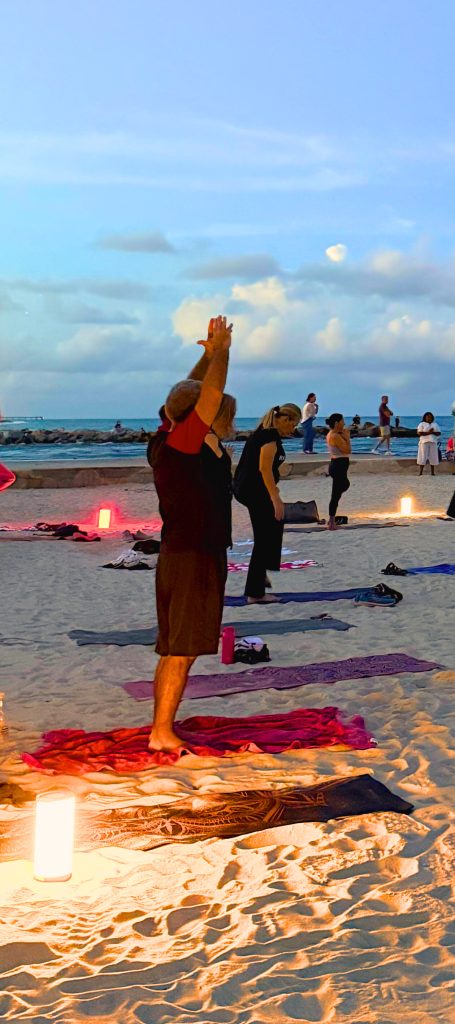 Yoga session on beach with candles